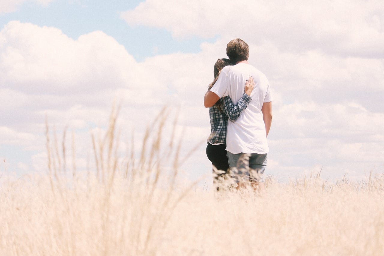 A couple standing in a field.
