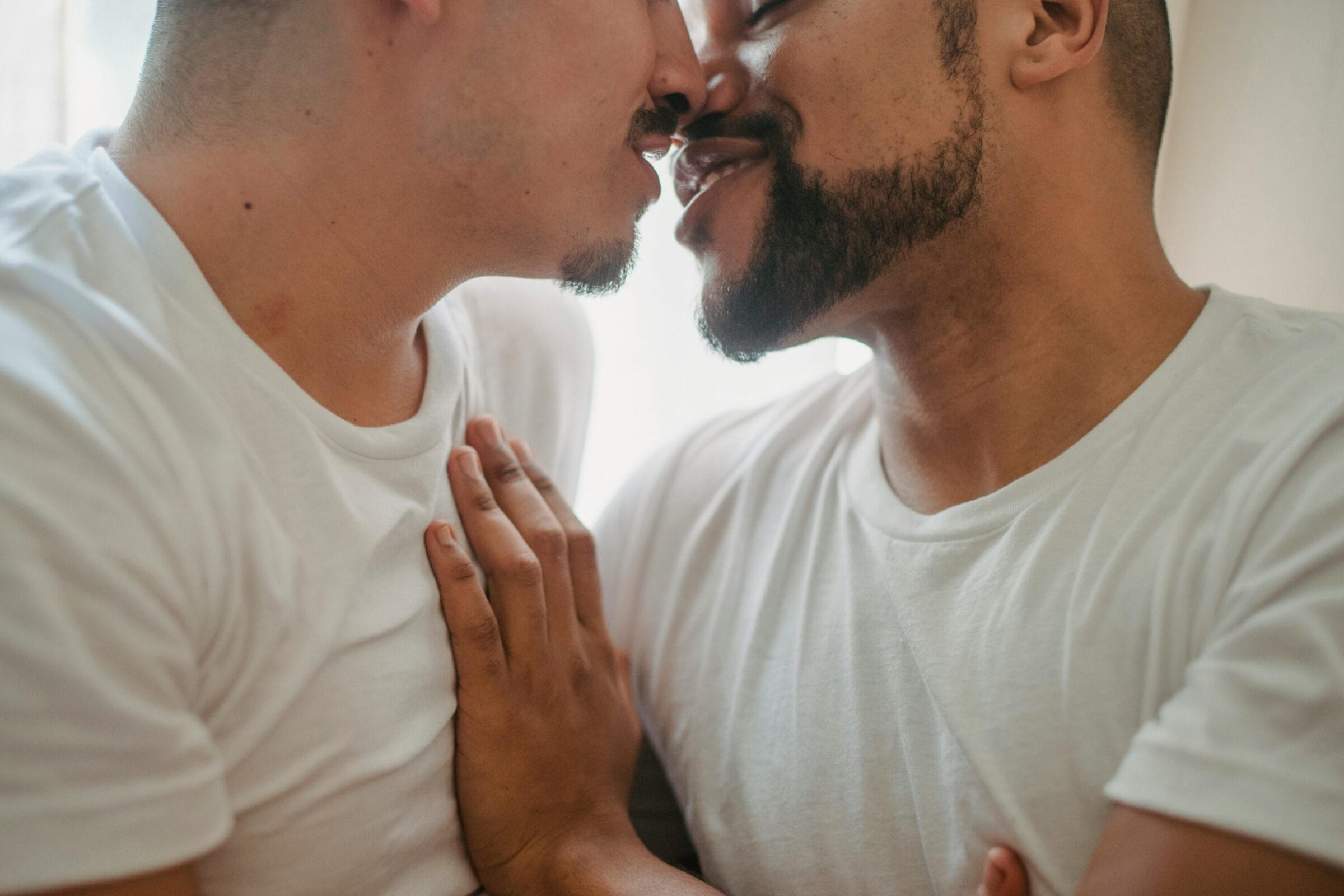 Couple in white t-shirts smiling and kissing