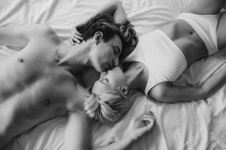 Couple laying face to face on bed in opposite directions